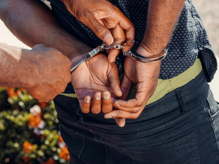 close-up of a police officer putting handcuffs on a man